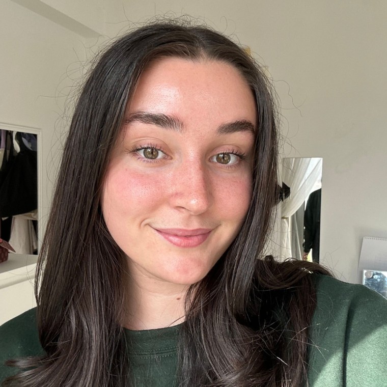 Women smiling holding up Tower 28 Makes Waves Mascara.