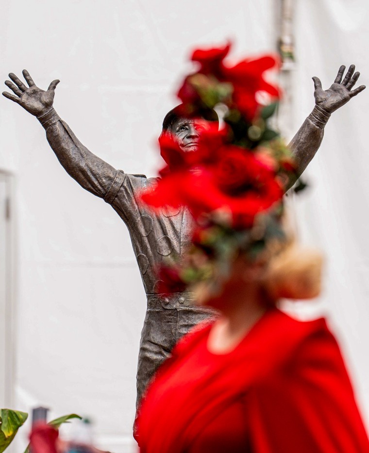 Race fans pass by the Pat Day statue.