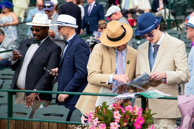 Attendees check racing forms of the prep races.