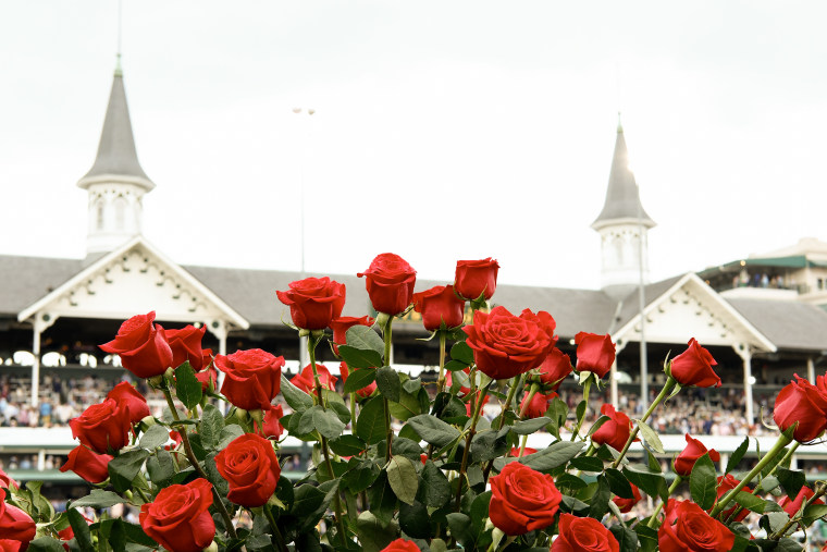 Red roses appear in the foreground before the twin spires of Churchill Downs.