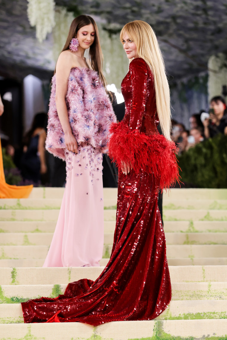 Nicole Kidman wears a sparkly red sequin dress, right, and Sunday Rose Kidman wears a puffy pink dress on the white carpet