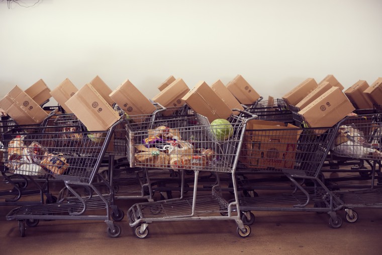 Volunteers filled grocery carts with food to load into vehicles at St. Mary’s Food Bank in Phoenix.