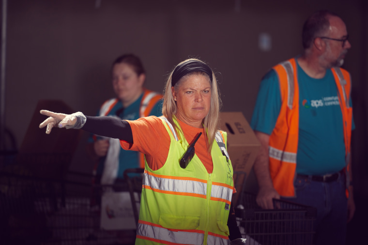 A volunteers at St. Mary’s Food Bank in Phoenix directs traffic the morning of April 29.