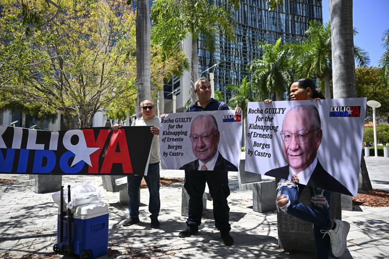 Protesters demanding the "maximum sentence" for former U.S. Ambassador to Bolivia, Victor Manuel Rocha, accused of spying for Cuba, outside court in Miami in 2024. 