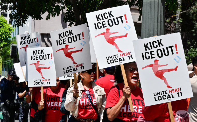 Protestors stand in a line holding signs that read "Kick ICE Out! Unite Here! Local 11"