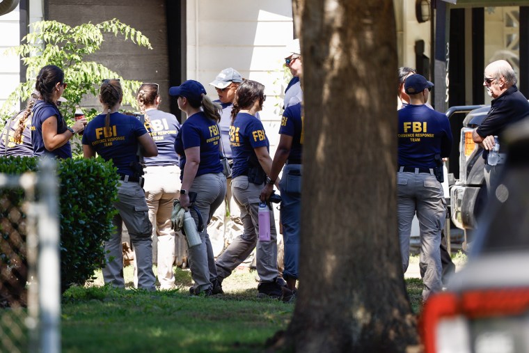 A twelve FBI grounds consequence squad workers successful matching bluish t-shirts pinch yellowish letters guidelines successful the beforehand gait of a home.