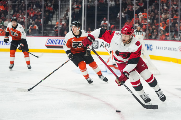 Taylor Hall prepares to hit a hockey puck on the ice