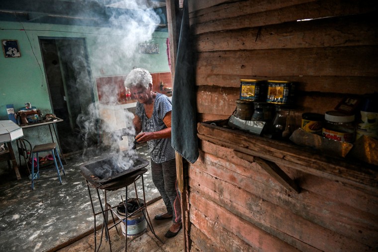 A woman cooks with charcoal at her home in Yaguaramas, Cienfuegos Province, Cuba, March 20, 2025.
