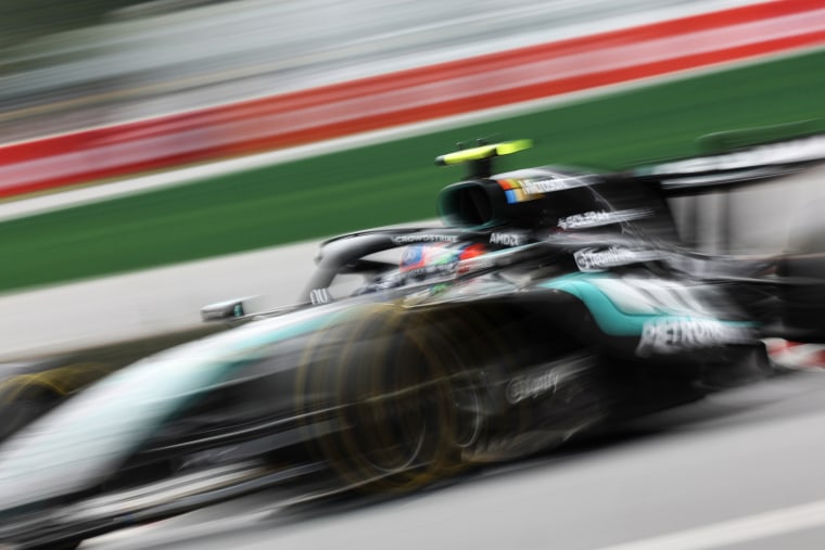 A blurred photo of a race car passing on the track.
