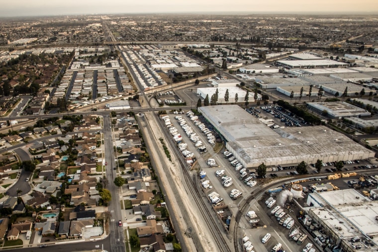 A drone photo of a suburban development at the edge of an industrial lot.
