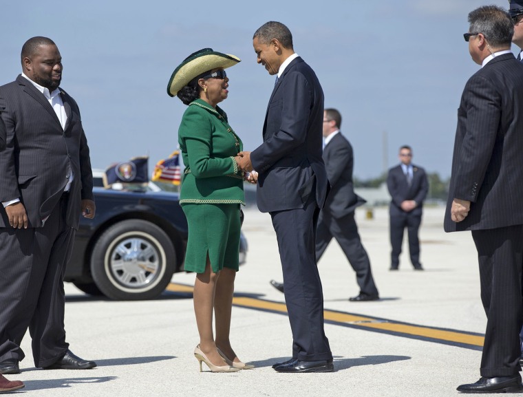 President Barack Obama is greeted by Rep. Frederica Wilson, D-Fla., center, and Florida State Rep. Dwight Bullard, left, arsenic he steps disconnected of Air Force One astatine Miami International Airport, Thursday, Oct. 11, 2012, successful Miami. 