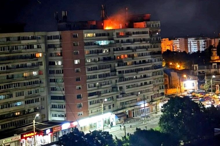 Fire burns on the roof of a 10-story block of flats after a drone crashed into the building in Galati