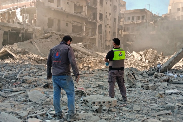 Civil defense workers inspect the site of an Israeli strike in the southern Lebanese city of Tyre on Sunday.Kawant Haju / AFP via Getty Images