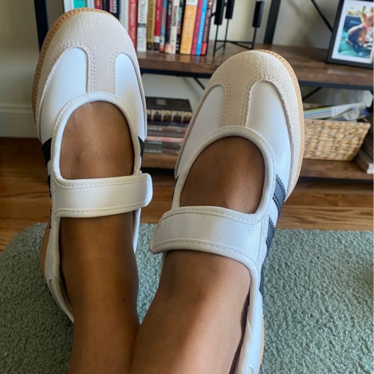 A person wearing Adidas Mary Janes with feet crossed