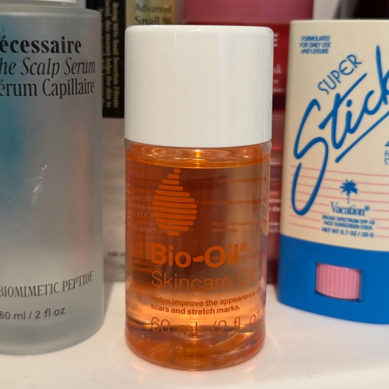 Bio-oil on a sink next to other beauty products.