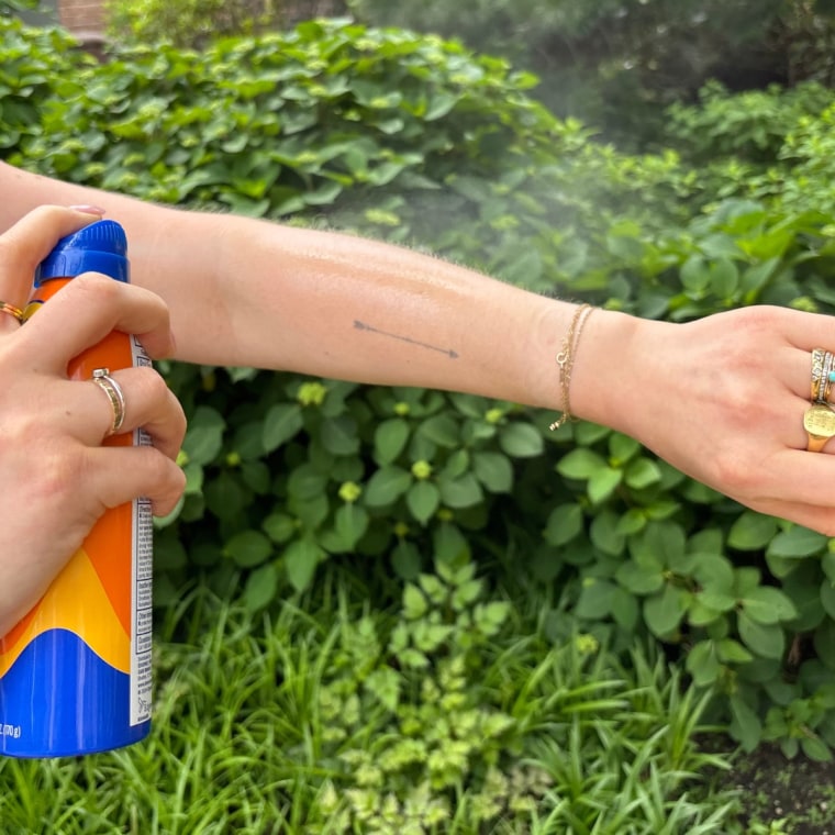 A woman applying Banana Boat’s Ultra Sport SPF 30 Sunscreen Spray.