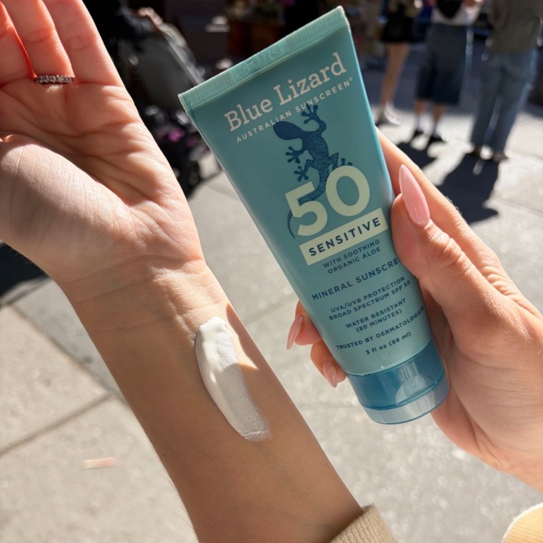 Woman applying sunscreen to arm