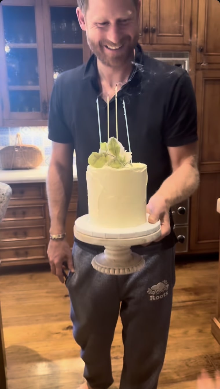El Príncipe Harry sosteniendo su pastel de aniversario.