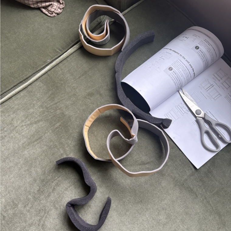Cutting foam pieces to complete the window installation process for the Midea portable air conditioner. 