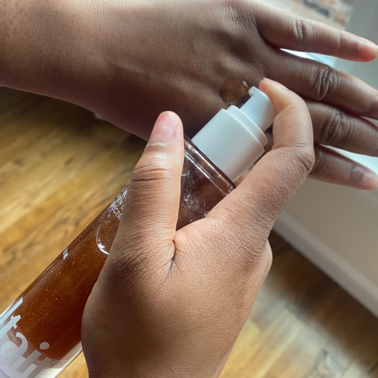 Woman applying sunscreen oil to her hand