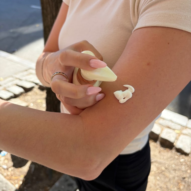 Woman applying sunscreen on arm