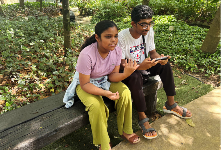 Siblings Saaradha Saravanan, 12, left, and Aadhavan Saravanan, 15, sit in a park in Petaling Jaya, Malaysia on Monday, June 1, 2026.