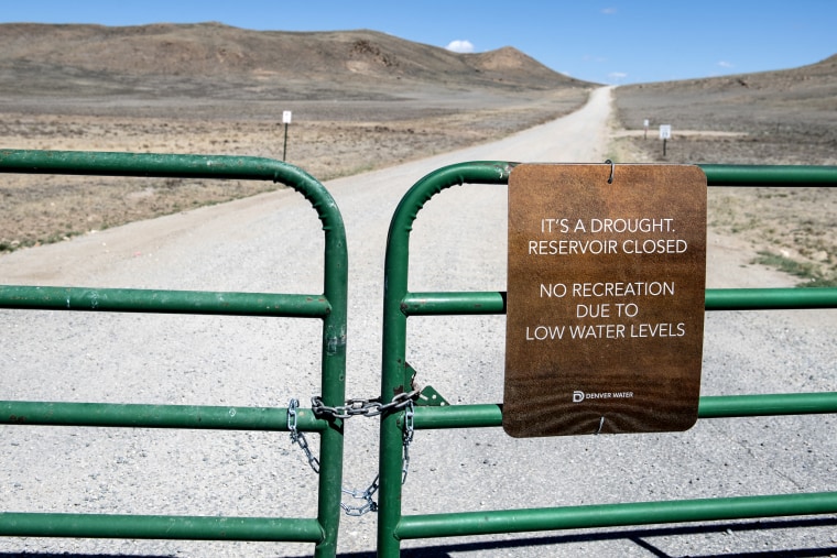 A sign hangs from a locked gate closing the road to the Antero Reservoir