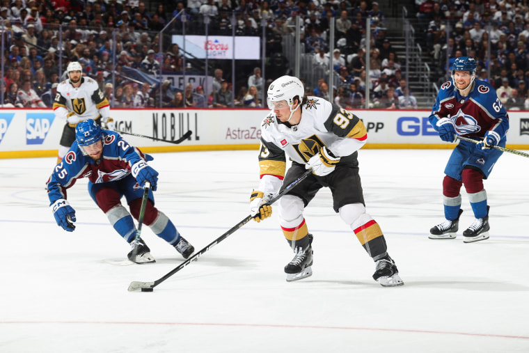 Mitch Marner, center, skates on the ice in a hockey uniform between other players