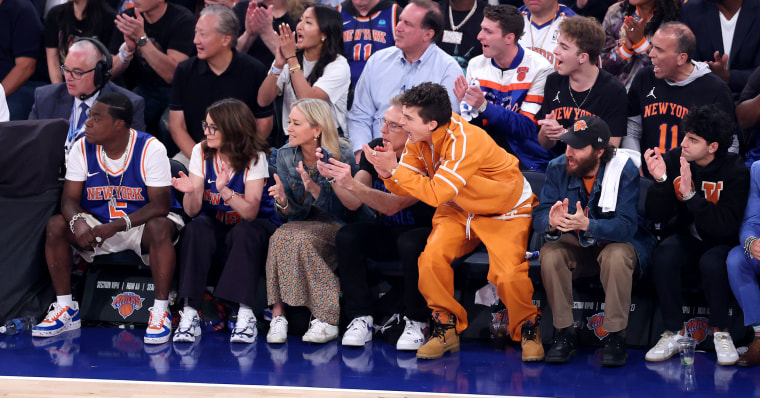 Celebrities sit courtside.