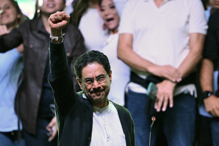 Iván Cepeda raises a fist into the air during a political rally.