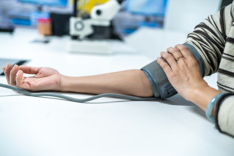 A pair of female hands measure blood pressure