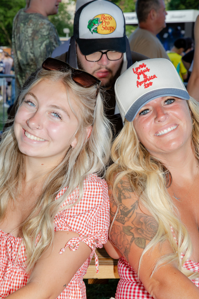 Portrait of two blonde haired, blue eyed women smiling.