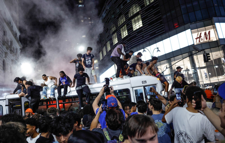 Knicks fans atop a bus in New York on June 14, 2026.