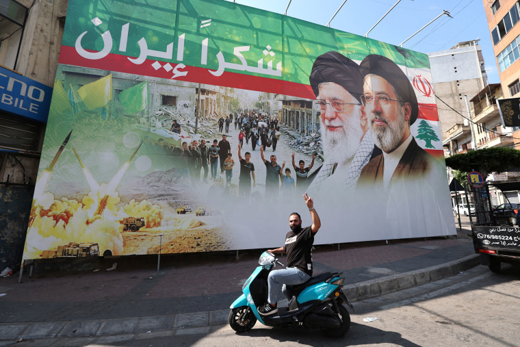 A man flashes the victory sign in front of a billboard depicting the late Iranian leader Ayatollah Ali Khamenei and Iranian Supreme Leader Ayatollah Mojtaba Khamenei in Beirut, Lebanon, on June 15, 2026. 