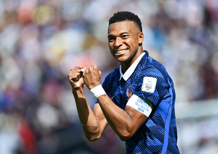 Mbappe curls his fists in celebration on the field