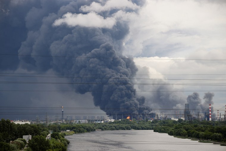 Thick plumes of smoke with flames rise from an oil refinery following a Ukrainian drone attack in Moscow