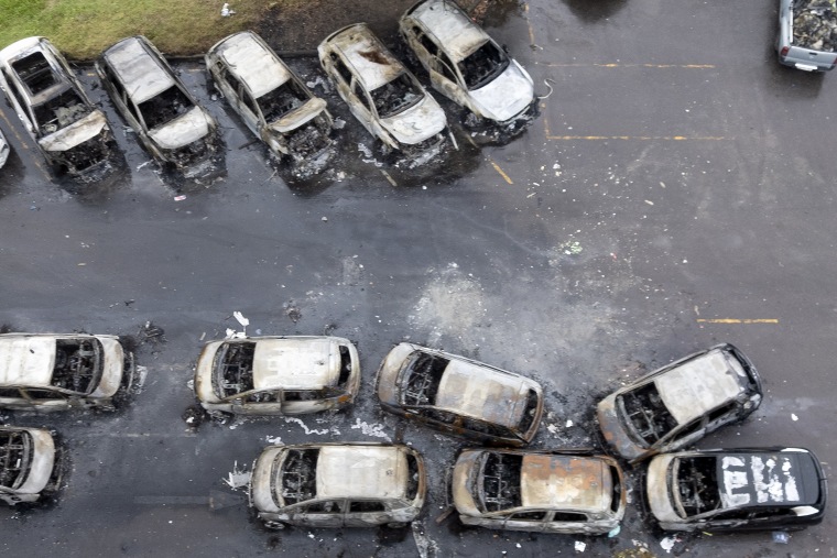 Charred vehicles seen from an overhead, aerial perspective.