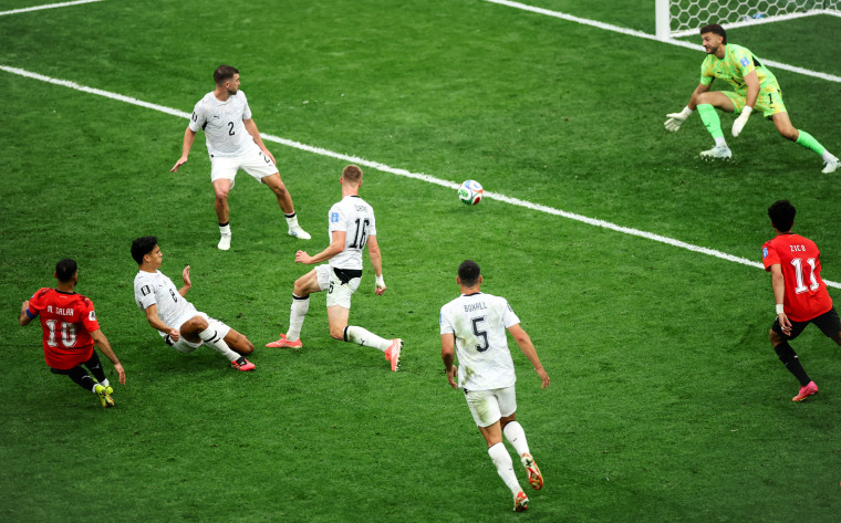 Mohamed Salah, left, kicks the ball across the field towards the net