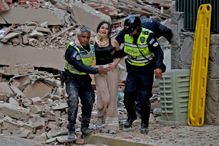 Police evacuate an injured victim from a collapsed building following an earthquake in Caracas on June 24, 2026. 