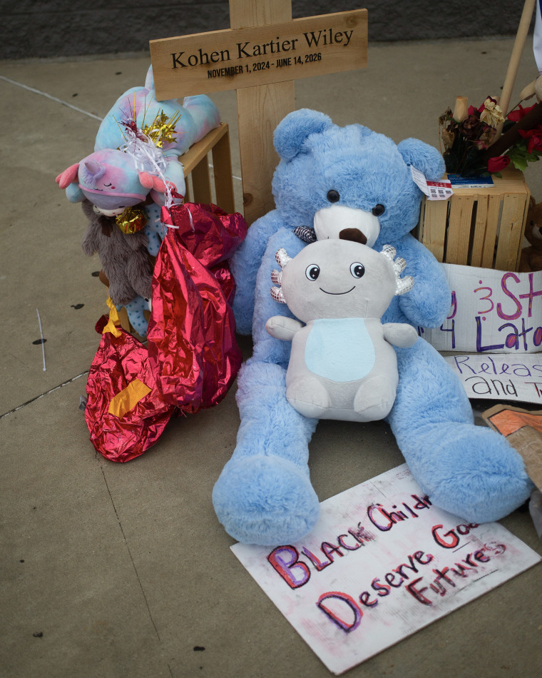 A memorial with stuffed animals in front of a Walmart.