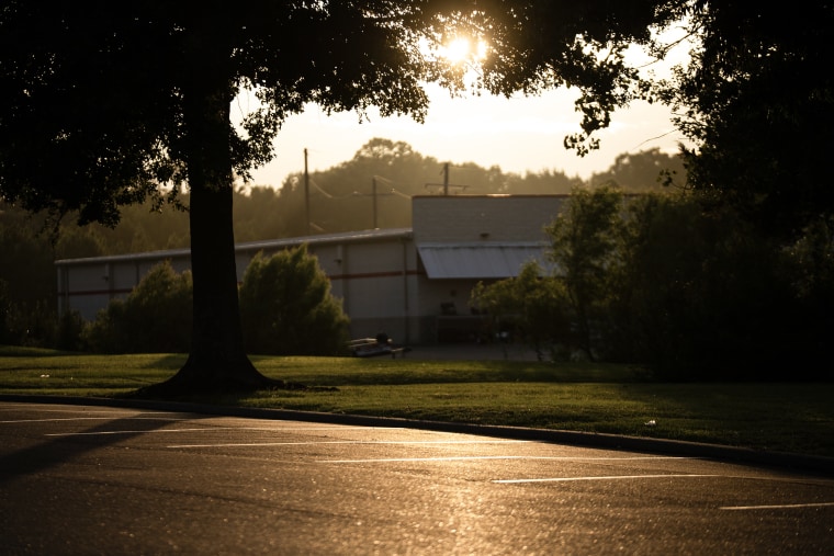 Warm light falls across an asphalt parking lot at sunset.