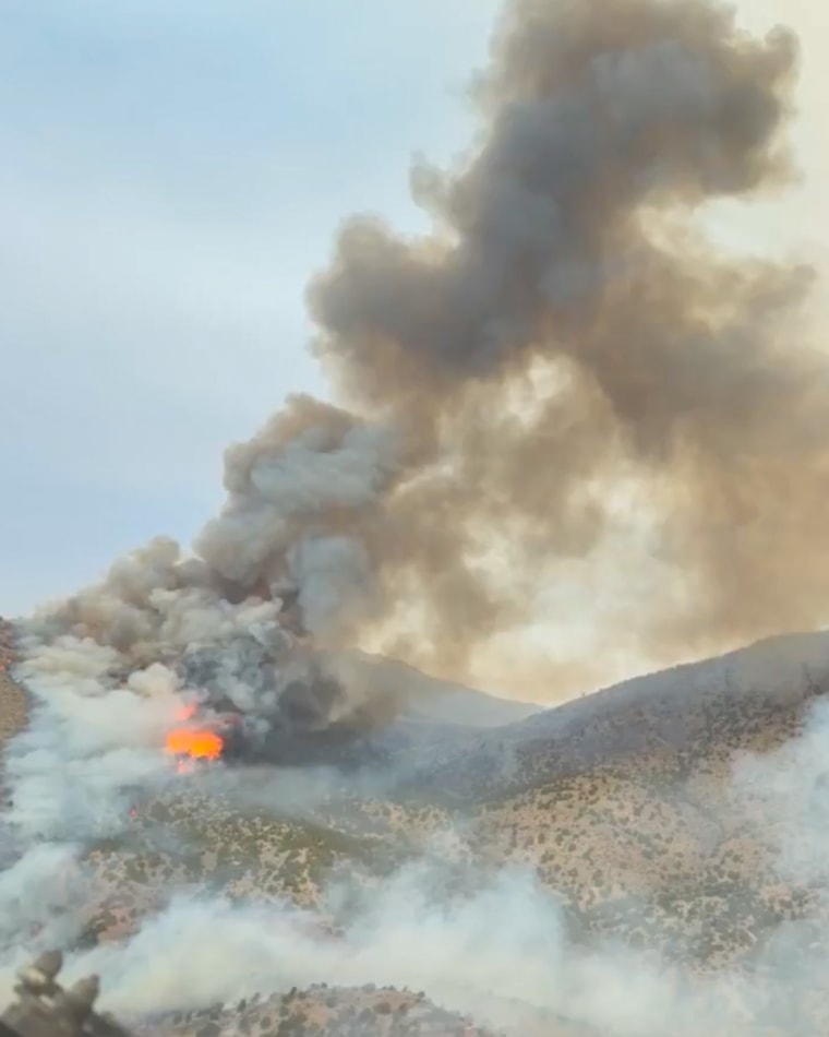 Close-up aerial video showing large billowing flames and massive plumes of smoke surrounding mountains in Eureka, Utah, on June 24, 2026.