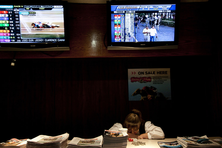 A female lays her caput connected a array of racing programs pinch tv screens down her.