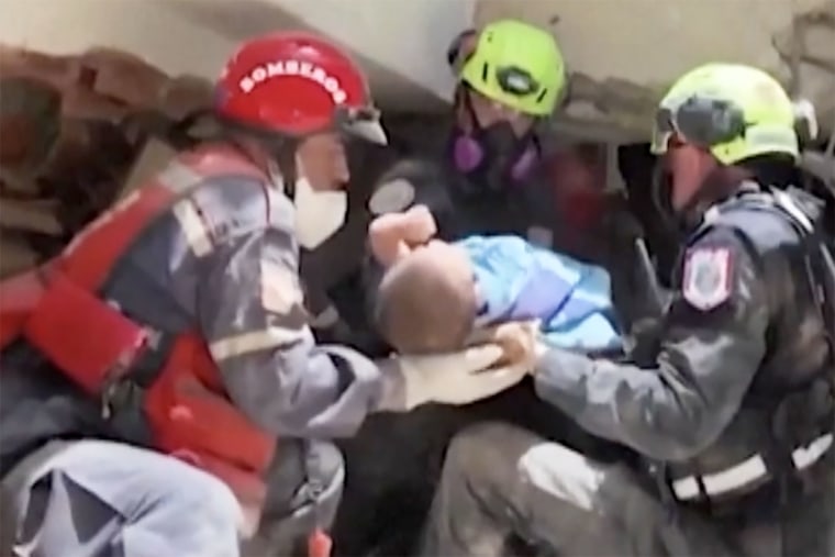 Rescue teams pull a 9-month-old from the rubble in Venezuela in a video released Saturday.