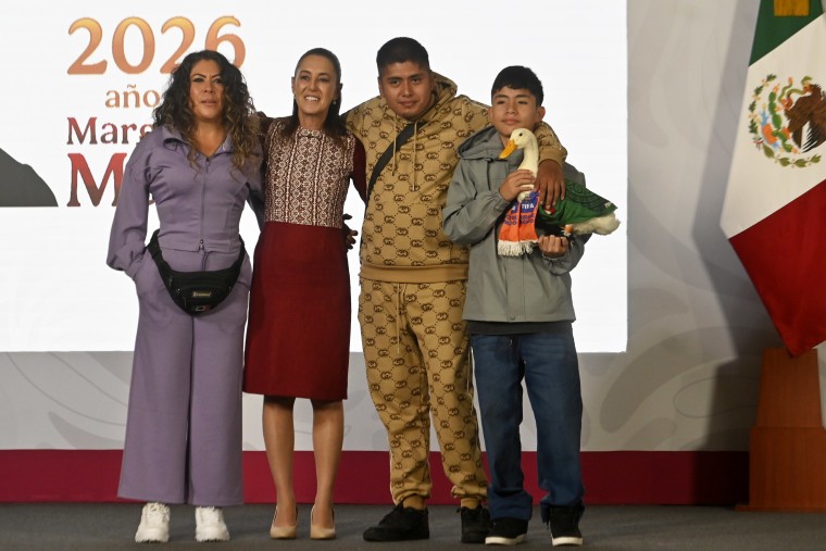 2026年6月22日、国立宮殿での朝の記者会見で、メキシコシティ（2026年ワールドカップ開催地）の大使に任命されたアヒルのカジキの飼い主たちとポーズをとるメキシコ大統領、クラウディア・シャインバウム。