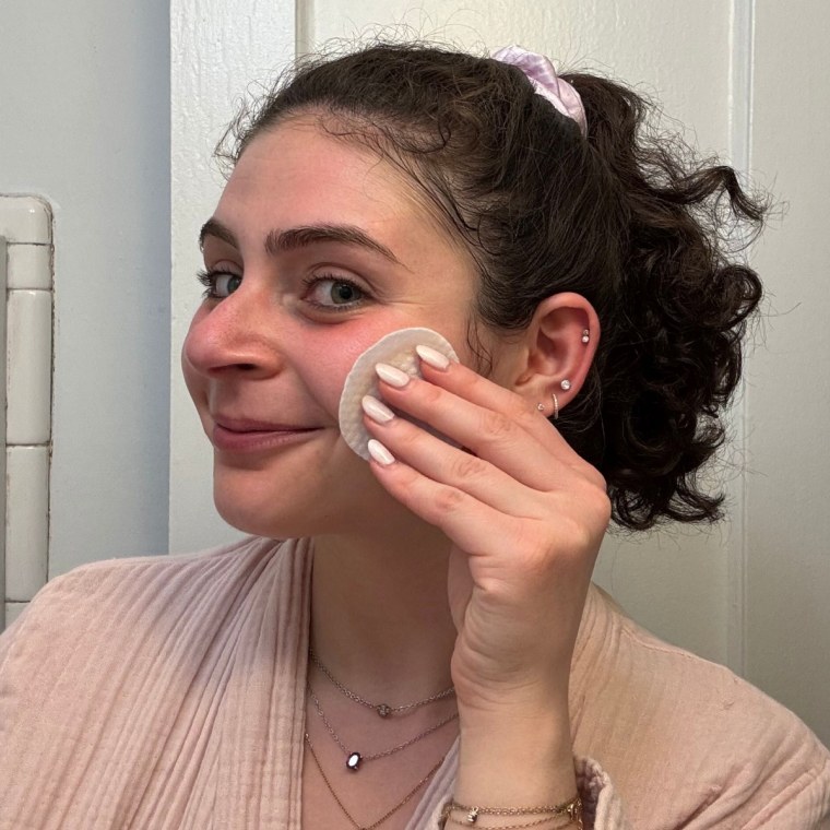 Woman applying toner pad to face