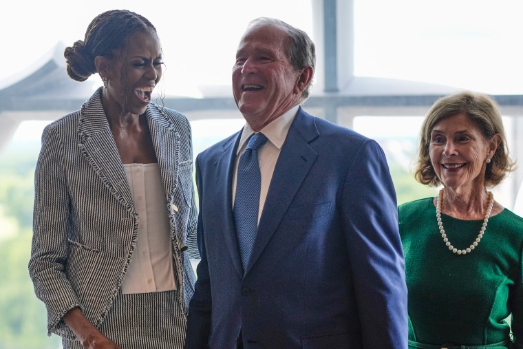 O ex-presidente George W. Bush ri com a ex-primeira-dama Michelle Obama.