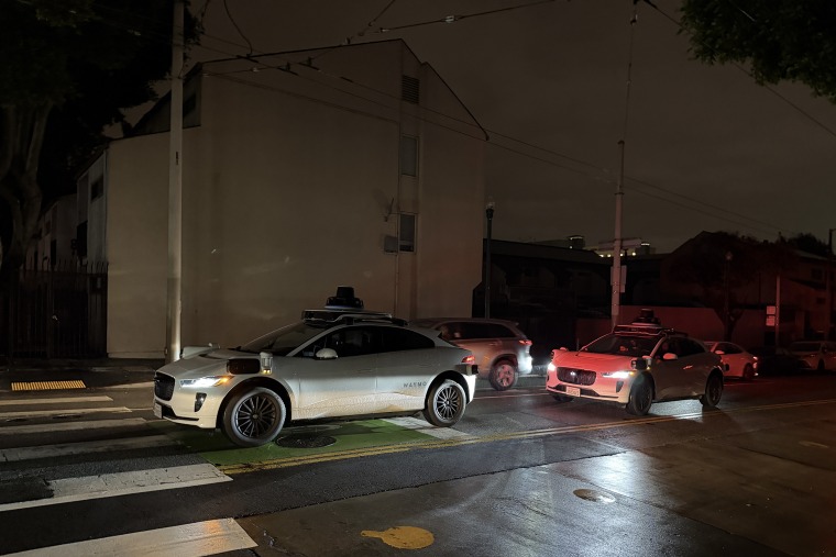 A self-driving car sits stalled in traffic during a power outage.