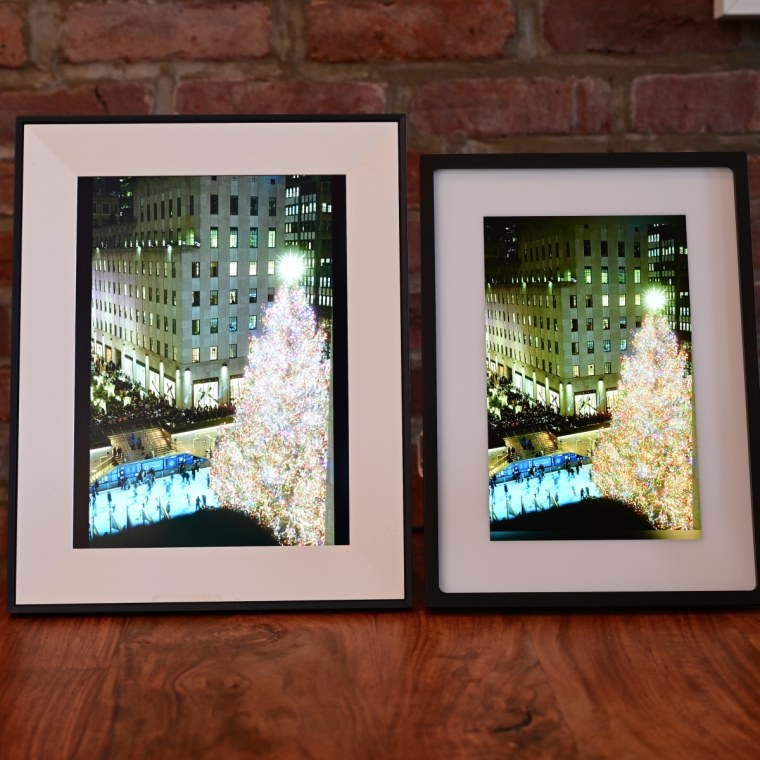 A side-by-side of the Aura Aspen and Skylight Frame 2, both displaying the same photo of a Christmas tree lit up in Rockefeller Center.