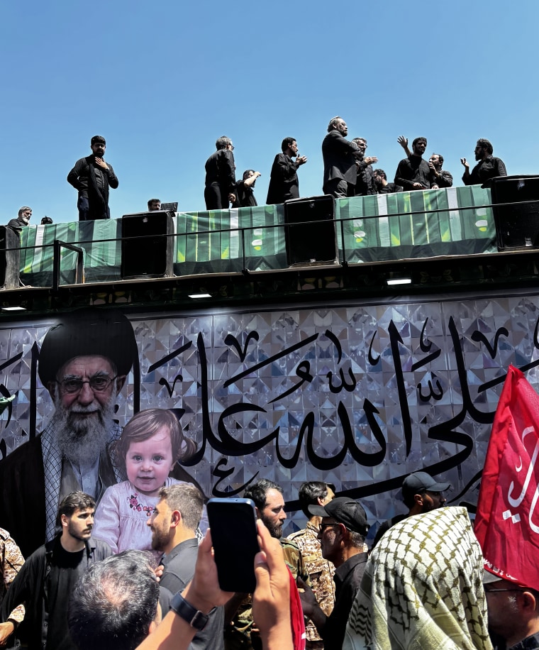 A photo of Khamenei with his 14-month-old granddaughter on display during the funeral procession.